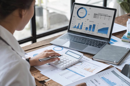 Business woman using calculator for do math finance on wooden desk in office and business working background, tax, accounting, statistics and analytic research concept.の写真素材
