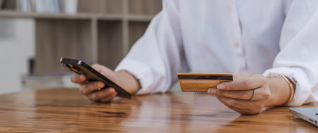 Close up of woman hand using mobile smart phone payments and credit card for online shopping,Online...