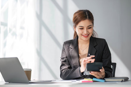 Business woman using calculator for do math finance on wooden desk in office and business working...