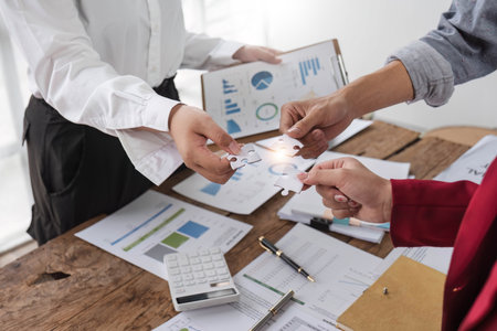 A group of business people assembling jigsaw puzzle. The concept of cooperation, teamwork, help and...