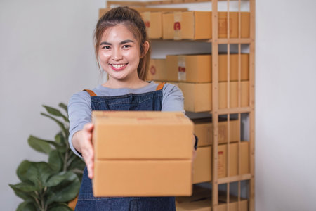 Online business concept, Asian business women holds parcel boxes of product for delivery to clientの写真素材