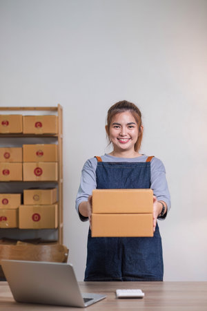 Online business concept, Asian business women holds parcel boxes of product for delivery to clientの写真素材