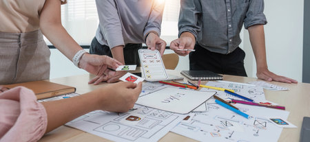 A close-up of an ux ui developer and an ui designer working on a mockup icon interface for a mobile appの写真素材
