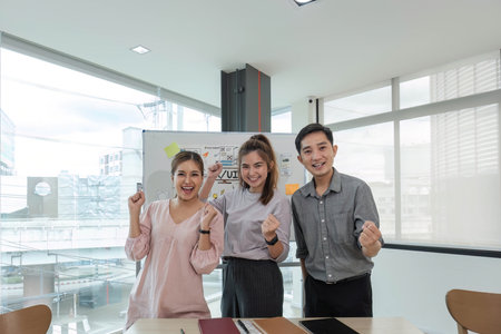 Asian female leader and ux ui designer clapping hand for successful of mobile app interface wireframe design at modern office. Creative digital development agencyの写真素材