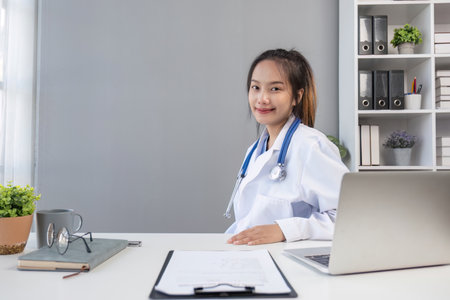 Young asian woman wearing doctor uniform smiling confident looking at the cameraの写真素材