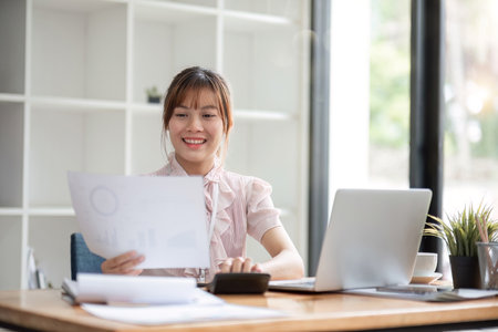 Asian Businesswoman Using laptop computer and working. Businesswoman doing accounting analysis report investment data, Financial at officeの写真素材