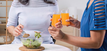 Two Asian woman enjoys talking with her friends while having a healthy food together.