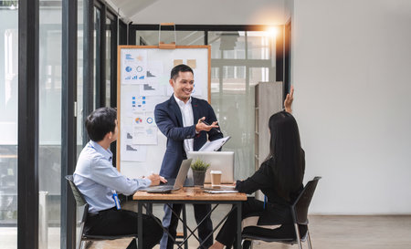 Professional businessman presenting to colleagues in conference room explaining growth chartの写真素材