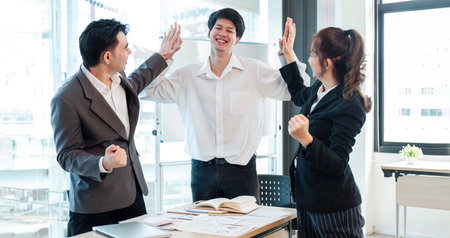 Successful business people celebrating teamwork in the office.の写真素材