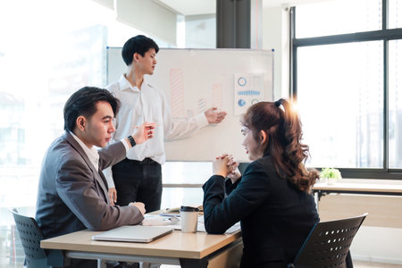 Presenting business plans of young businessmen to colleagues and exchanging ideas within the organization.の写真素材
