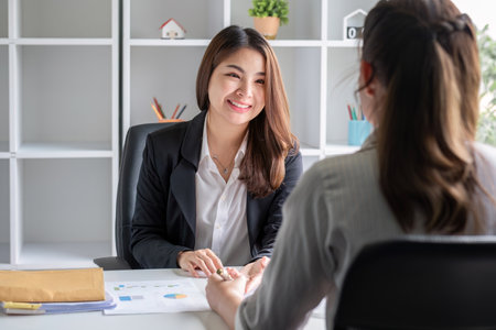 Businesswoman consulting work on taxes and income calculations together to brainstorm work ideas.の写真素材