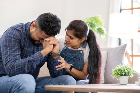 A young woman encourages and holds the hand of her worried husband. is having a hard time making some decisions.の写真素材