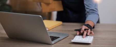 SME entrepreneurs press the calculator to calculate the value of the products according to the...