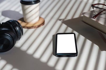 Flat lay home office desk. workspace with headphones, smartphone with empty screen mockup, coffee cup. Top view background.の写真素材