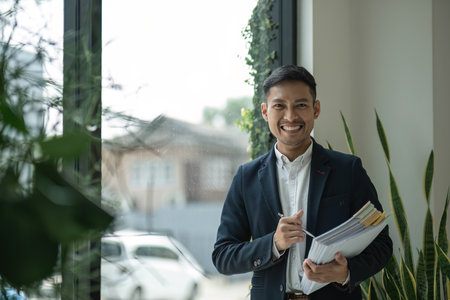 Portrait of a young businessman with work documents Successful businessman managing business documents.の写真素材