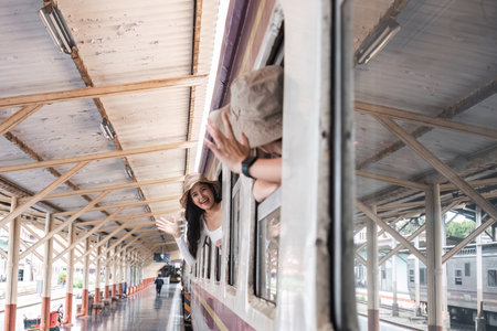 Two young female tourists are happy while waiting for their train at the train station to leave for...