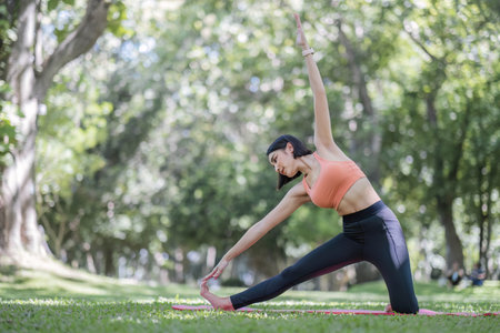 Attractive and charming Asian woman in her 30s in sportswear doing yoga poses, relaxing muscles....