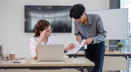 Concentrated male employee explaining meeting minutes to serious looking female employee...
