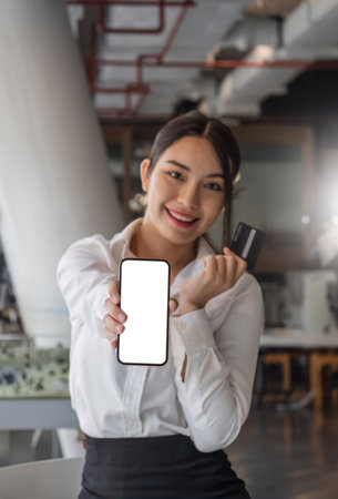 beautiful Asian woman holding smartphone mockup of blank screen and show credit card