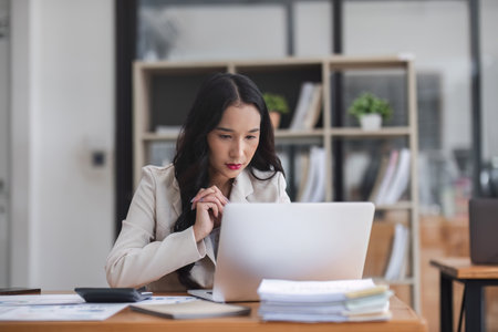 Business woman using calculator for do math finance on wooden desk in office and business working background, tax, accounting, statistics and analytic research concept.の写真素材