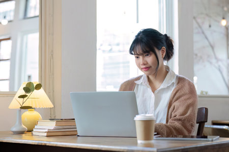 Asian female student studying online, studying on a video call, zoom call, passionate Asian female teacher learning English online with a laptop computerの写真素材