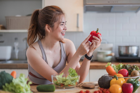 Sporty young woman is preparing healthy food on light kitchen. healthy food concept.の写真素材