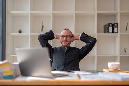 portrait of Happy businessman looking at laptop computer in office, Excited man working at his workplace at modern co-working, successful peopleの写真素材