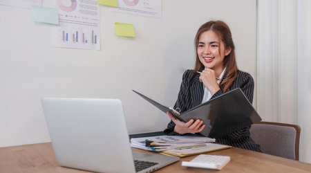Cheerful business lady working on laptop in office, Asian happy beautiful businesswoman in formal...