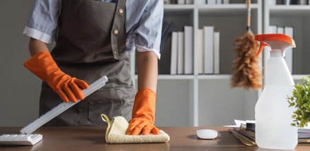 Close up, Young woman uses a cleaning cloth to disinfect the computer and equipment on the office...