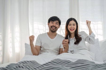 Love, happiness and a couple in bed on a beautiful morning at home. Wake up together brightly Woman and man relax in bedroom, romance, happinessの写真素材