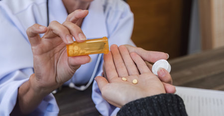 Close up, Elderly female doctor in white coat talking with beautiful young patient in clinic, giving advice on heart disease treatment and health care and medicine, medicine conceptの写真素材