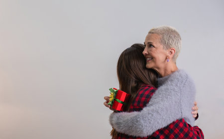 Merry Christmas Retired woman and her eldest daughter Exchange gifts Have fun hugging each other happily during the Christmas holiday season.の写真素材