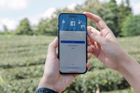 CHIANG MAI, THAILAND - OCT 25, 2023: Facebook social media app logo on log-in, sign-up registration page on mobile app screen on iPhone 14 in persons hand working on e-commerce shopping businessのeditorial素材