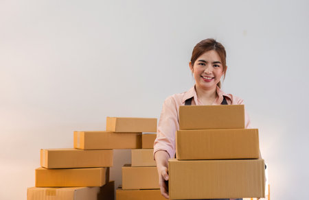 Portrait of starting a small business SME business owner Female entrepreneur working on merchandise boxes Receipts and checks online orders to prepare boxes for seller to customers.の写真素材