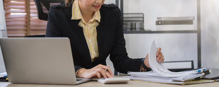 Close up, Businesswoman uses calculator to calculate finances, mathematics on table in office and...