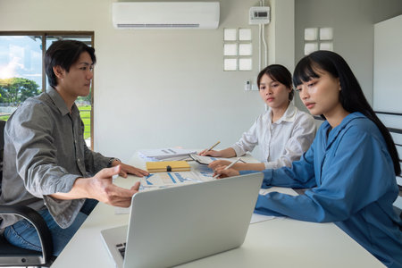 A professional business team is meeting to discuss company management practices in a modern conference room.の写真素材