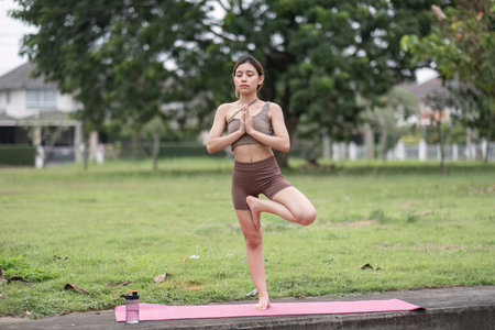 Young Asian woman exercise Do yoga in the park to improve your health.