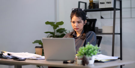 Puzzled confused asian woman thinking hard concerned about online problem solution looking at laptop...