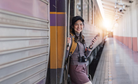 Young Asian woman in modern train station Female backpacker passenger waiting for train at train...