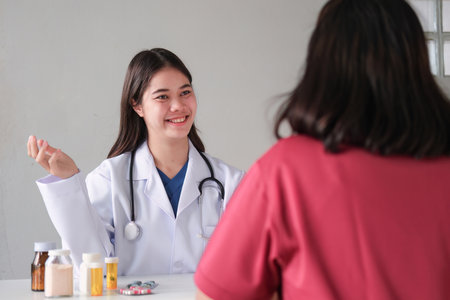 An Asian female doctor is consulting a patient who comes to discuss taking medication for health care. and treat disease with medicineの写真素材
