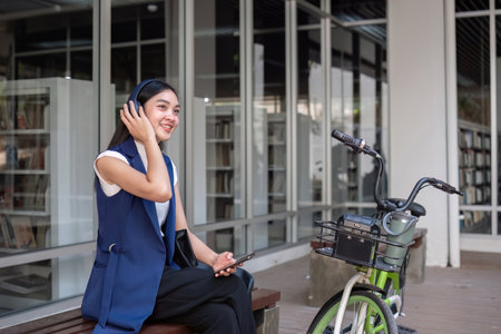Asian businesswoman ride a bicycle in the city to work outside the city to reduce carbon emissions. Alternative transportation for green energyの写真素材