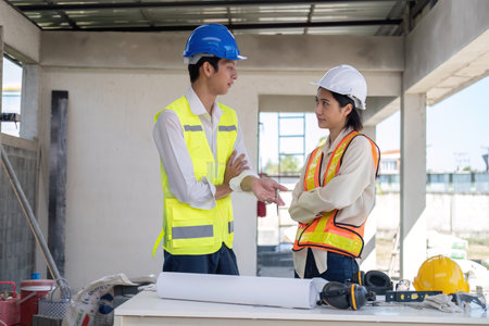 Civil engineer teams meeting working together wear worker helmets hardhat on construction site in modern city. Foreman industry project manager engineer teamwork. Asian industry professional teamの写真素材