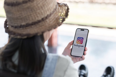 CHIANG MAI, THAILAND - JAN 18 2024: A woman holds Apple iPhone 14 with Instagram application on the screen at cafe. Instagram is a photo-sharing app for smartphonesのeditorial素材