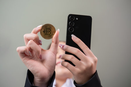 A successful business woman holds the cryptocurrency Bitcoin in her hands. Concept of trading and...