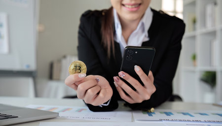 A successful business woman holds the cryptocurrency Bitcoin in her hands. Concept of trading and using digital currenciesの写真素材
