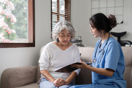 Elderly caregivers are helping to check the health and care for an elderly woman at home.の写真素材