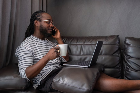 Young African American businessman spends his free time working from home on his laptop.の写真素材
