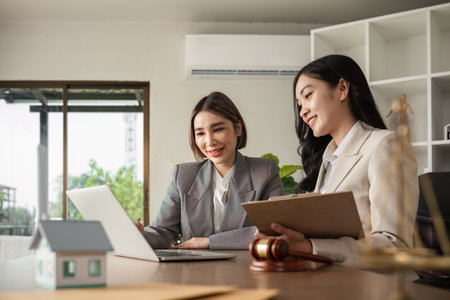 A young Asian lawyer and businesswoman discuss business law and financial contracts.の写真素材
