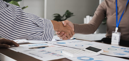 Two Asian businesswomen shaking hands in the office. Concept of partnership and agreement
