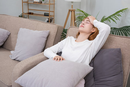 Young Asian woman has headaches from illness or accumulated stress due to health problems and lifestyle problems that cause stress disorder.の写真素材
